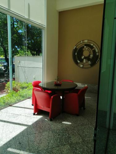 a table and chairs in a room with a window at Bristol Praia do Canto Apart Hotel in Vitória