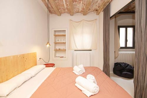una camera da letto con un letto e due asciugamani di Bonito apartamento en el Barri Vell Girona a Girona