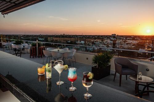 a rooftop bar with glasses on a table with a view at Mesón de la Luna Hotel & Spa in Mérida