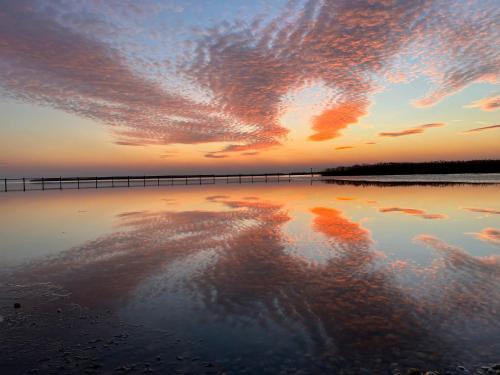 um pôr-do-sol sobre um corpo de água com um cais em Entspanntes Landleben Rustikales Ferienhaus mit Kreativer Arbeitsatmosphäre im Urlaubsparadies em Gols