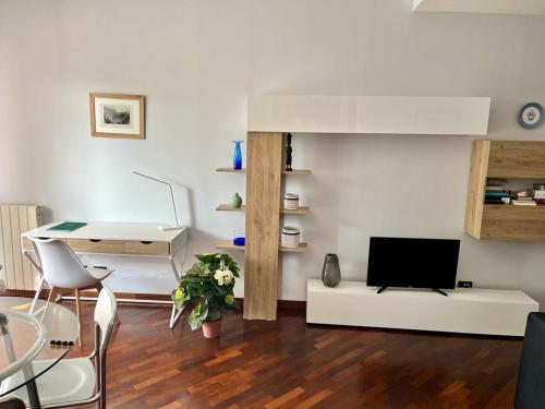 ein Wohnzimmer mit einem Schreibtisch und einem TV in der Unterkunft INTERO APPARTAMENTO EUR Torrino NUOVO LiFeHome in Rom