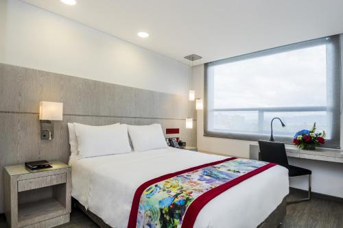 a hotel room with a large bed and a window at Hotel Black Tower Premium in Bogotá