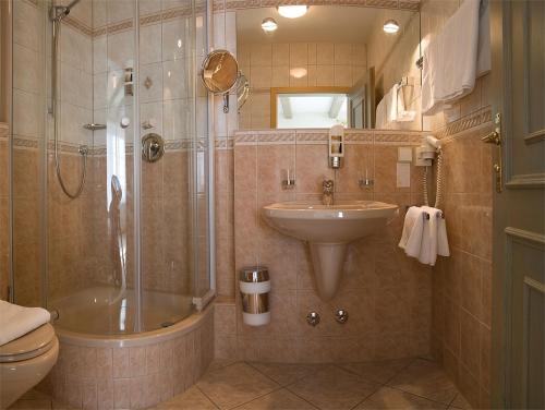 uma casa de banho com um lavatório, um chuveiro e um WC. em Hotel DREI SCHWANEN - Ristorante Due Fratelli em Hohenstein-Ernstthal