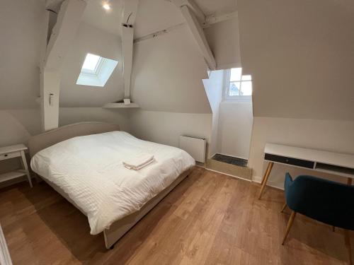 a bedroom with a bed and a desk and a window at Le cottage de l’Oudon in Segré