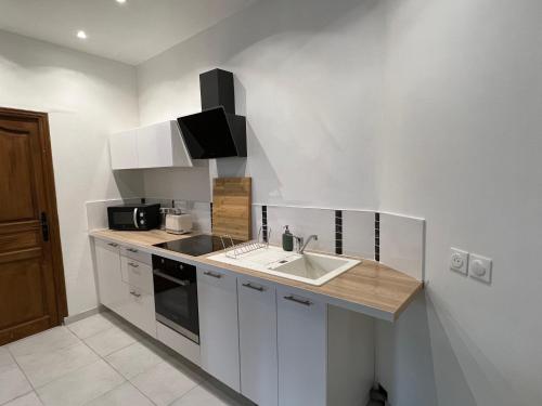 une cuisine avec un évier et un plan de travail dans l'établissement Le cottage de l’Oudon, à Segré