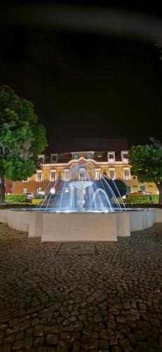 una fuente de agua frente a un edificio por la noche en RIVERINN Casa Familiar T 3 c Acesso Terraço 1 andar en Portimão