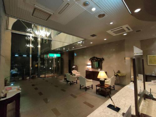 a lobby of a building with chairs and a lamp at Inuyama City Hotel in Inuyama