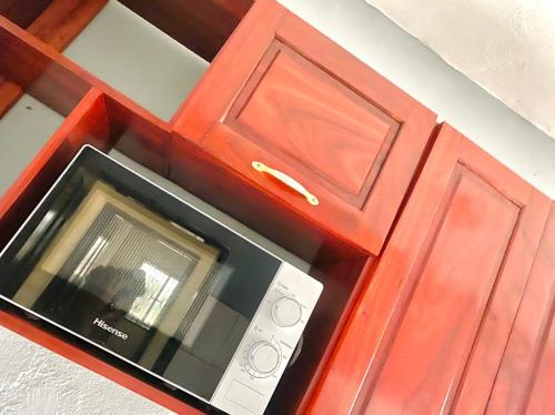 a red cabinet with a microwave in it at APEX ANNEX Guest Facility in Buea
