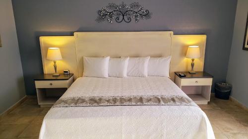 a bedroom with a large white bed with two night stands at Combate Beach Resort in Cabo Rojo