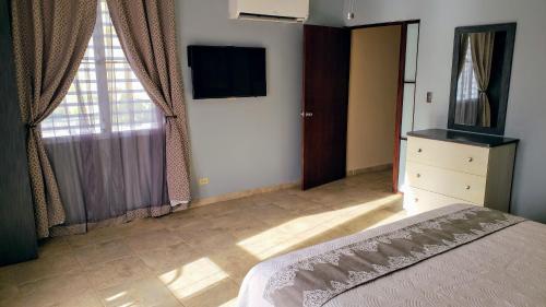 a bedroom with a bed and a television on the wall at Combate Beach Resort in Cabo Rojo