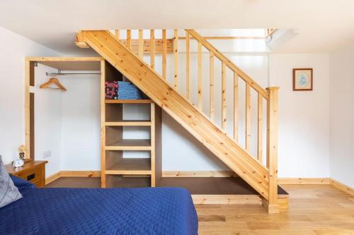 a loft bed with a staircase in a bedroom at Cornwall - Unique two storey barn in St Austell