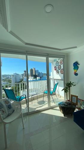 un soggiorno con vista su un balcone con sedie di Hermoso Apto Excalibur Rodadero a Santa Marta