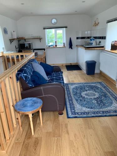 a living room with a couch and a table at Cornwall - Unique two storey barn in St Austell