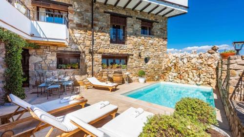 a villa with a swimming pool in front of a building at NEW!!! Casa El Imperio in Gaucín
