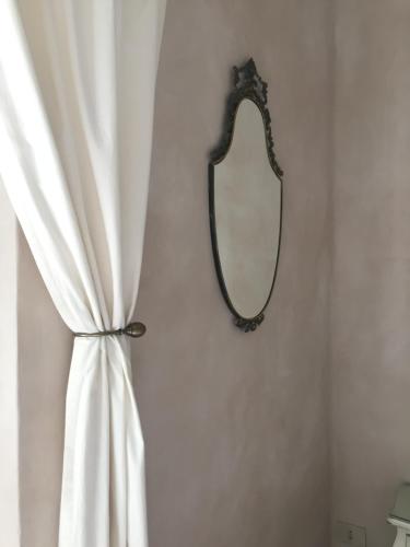 a mirror hanging on a wall next to a curtain at B&B Aquilone in Urbino