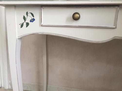 a white dresser with a drawer with a flower sticker on it at B&B Aquilone in Urbino