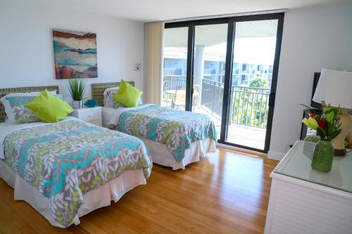 a hotel room with two beds and a balcony at Latitude Penthouse Key West in Key West