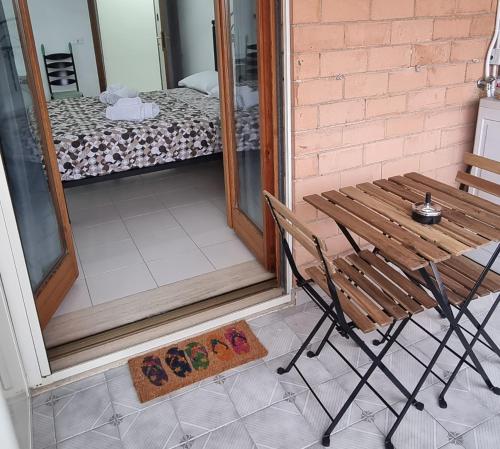 a wooden table and a chair on a porch at B&b Binario38 in Benevento