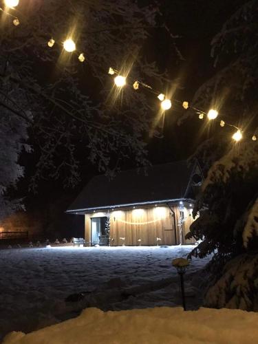 a cabin in the snow at night with lights at Mała Gorczańska Chatka in Ochotnica Dolna