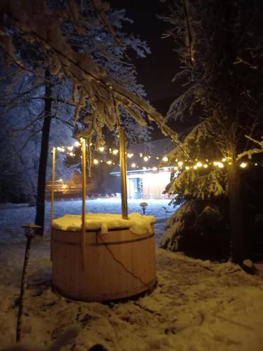 a hot tub in the snow with christmas lights at Mała Gorczańska Chatka in Ochotnica Dolna
