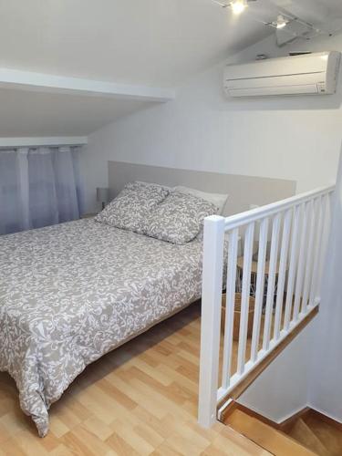 1 dormitorio blanco con 1 cama y escalera en L'Abri Côtier, l'appart 60m2, 1 chb avec terrasse, en Caux