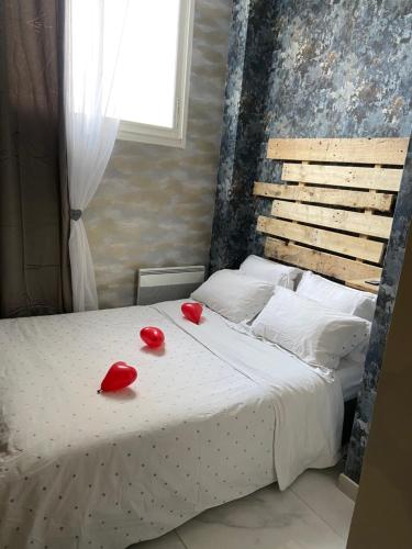 - un lit avec 2 chaussures rouges au-dessus dans l'établissement Nuit privée, à Cannes