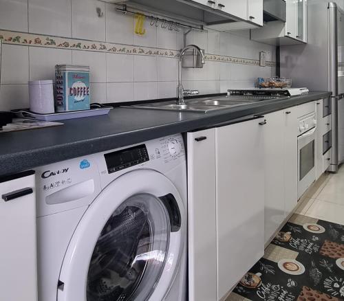 eine Küche mit einer Waschmaschine und einem Waschbecken in der Unterkunft B&b Binario38 in Benevento