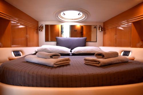 ein großes Bett in einem Zimmer mit Handtüchern darauf in der Unterkunft Luxury Yacht Kamikara in San Miguel de Abona