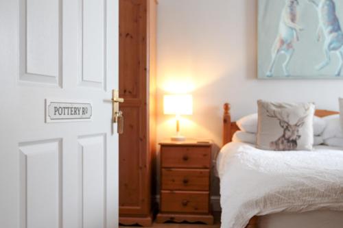 a bedroom with a bed and a table with a lamp at The Five Dials Inn in Ilminster
