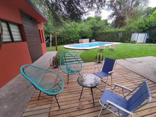 a deck with chairs and a table and a pool at ESPACIO RAKU in Ciudad Lujan de Cuyo