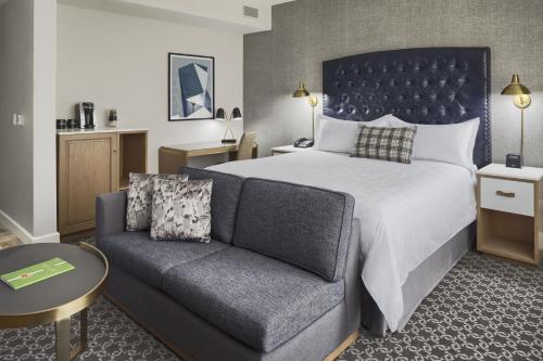 a hotel room with a bed and a couch at Hotel Teatro in Denver