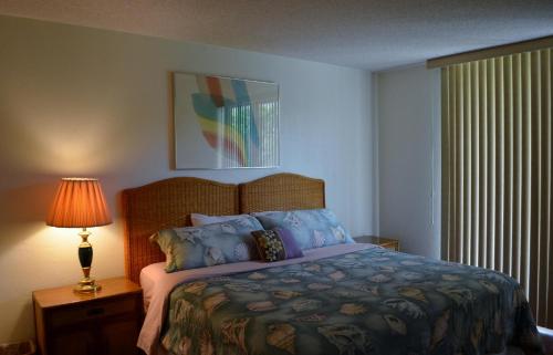 a bedroom with a bed and a lamp and a window at Paradise Found Cayo Hueso in Key West