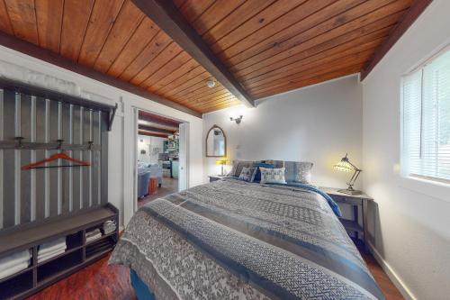 a bedroom with a large bed with a wooden ceiling at Bay Bliss in Reedsport