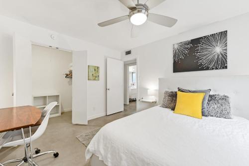 - une chambre blanche avec un lit et un bureau dans l'établissement Walk to SoCo Stylish Mid Century Gem by Lodgewell, à Austin