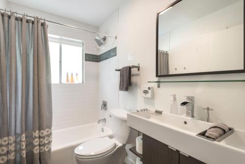 a bathroom with a sink and a toilet and a mirror at Quiet Haven with Huge Fenced Yard Fast Internet by Lodgewell in Austin