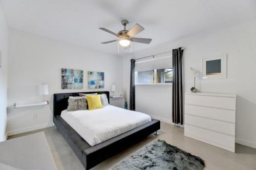 um quarto com uma cama e uma ventoinha de tecto em Sunny Mid Century Modern with Parking Patio and Fenced Yard by Lodgewell em Austin