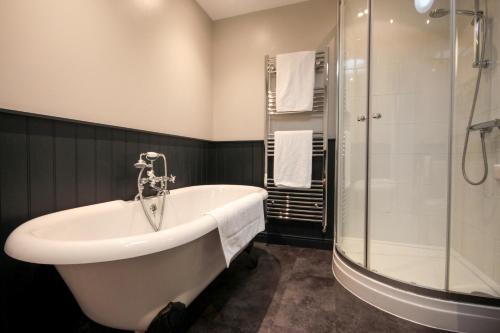 a bathroom with a bath tub and a shower at The Five Dials Inn in Ilminster
