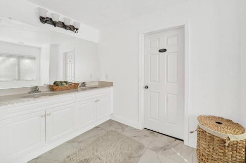 a white kitchen with white cabinets and a sink at Vino Villa Large home Sleeps 10! Large Salt water pool/spa in Murrieta