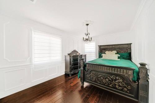 a bedroom with a green bed in a white room at Vino Villa Large home Sleeps 10! Large Salt water pool/spa in Murrieta