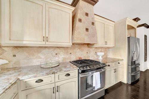 a kitchen with white cabinets and a stove top oven at Vino Villa Large home Sleeps 10! Large Salt water pool/spa in Murrieta