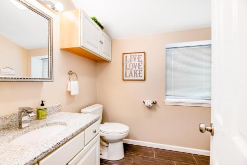 a bathroom with a toilet and a sink and a mirror at Live Laugh Lake - A in Rushville