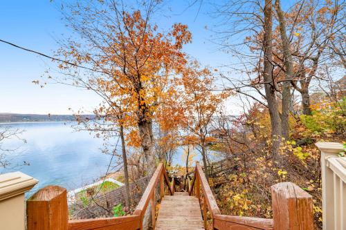 a wooden stairway leading down to a lake with trees at Live Laugh Lake - A in Rushville