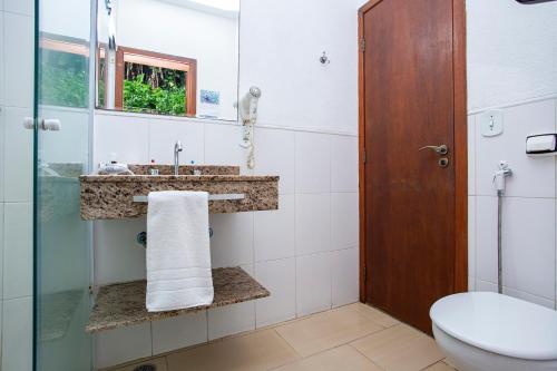 a bathroom with a sink and a toilet at Hotel Praia do Portinho in Ilhabela