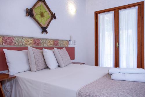 a bedroom with a large white bed with white pillows at Hotel Praia do Portinho in Ilhabela