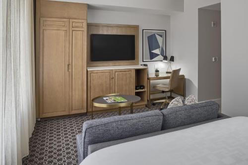 a hotel room with a couch and a television at Hotel Teatro in Denver
