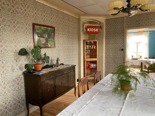 a dining room with a table and a dresser at Strandgården Hoverberg. in Svenstavik