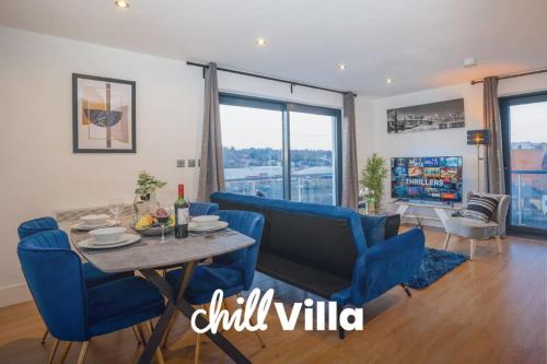 a living room with a table and blue chairs at NEW Stunning Rooftop Terrace Flat-Town Centre in Kent