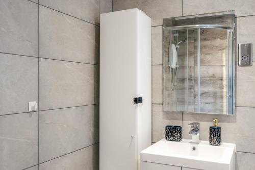 a bathroom with a white sink and a shower at NEW Stunning Rooftop Terrace Flat-Town Centre in Kent