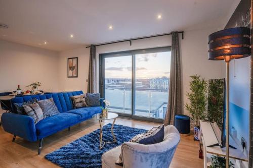 a living room with a blue couch and a large window at NEW Stunning Rooftop Terrace Flat-Town Centre in Kent