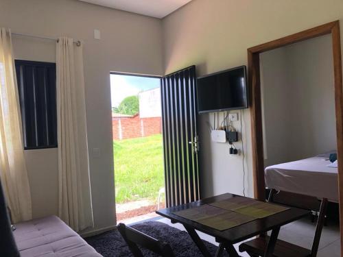 a room with a table and a bed and a window at CASA DE TEMPORADA DA MEiRE in Carolina
